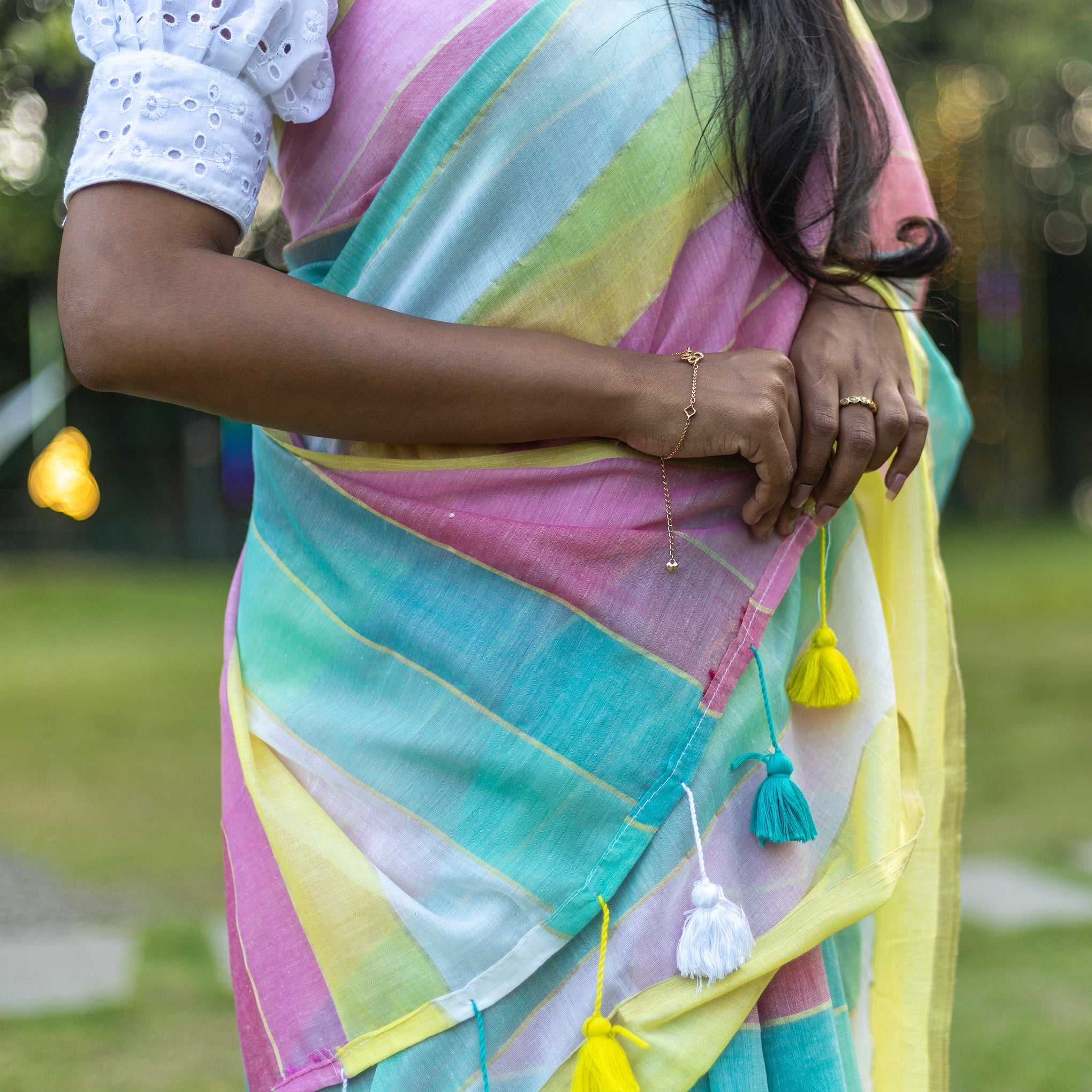 Woman wearing a colorful saree with a blurred outdoor background