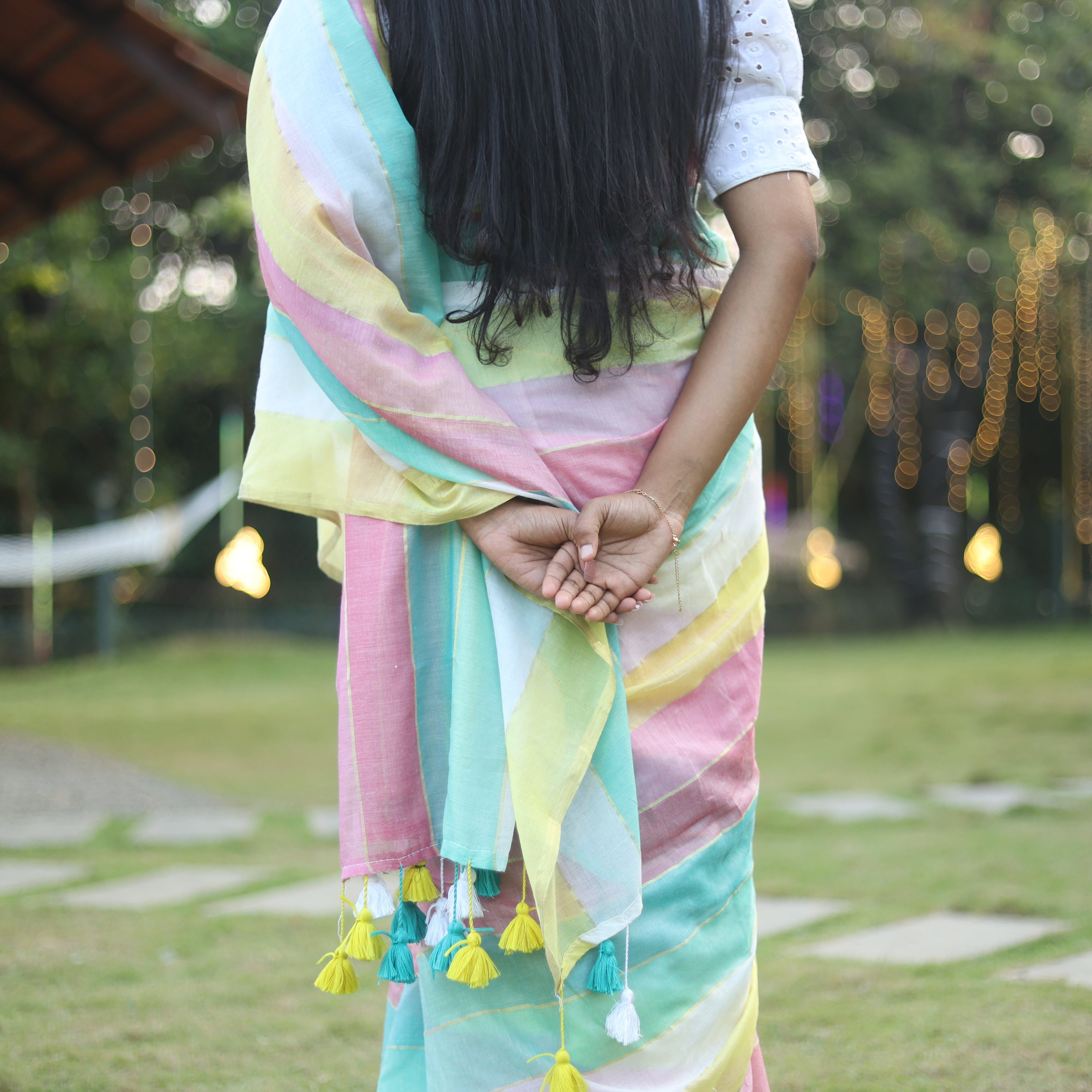 Person wearing a colorful scarf with tassels in an outdoor setting