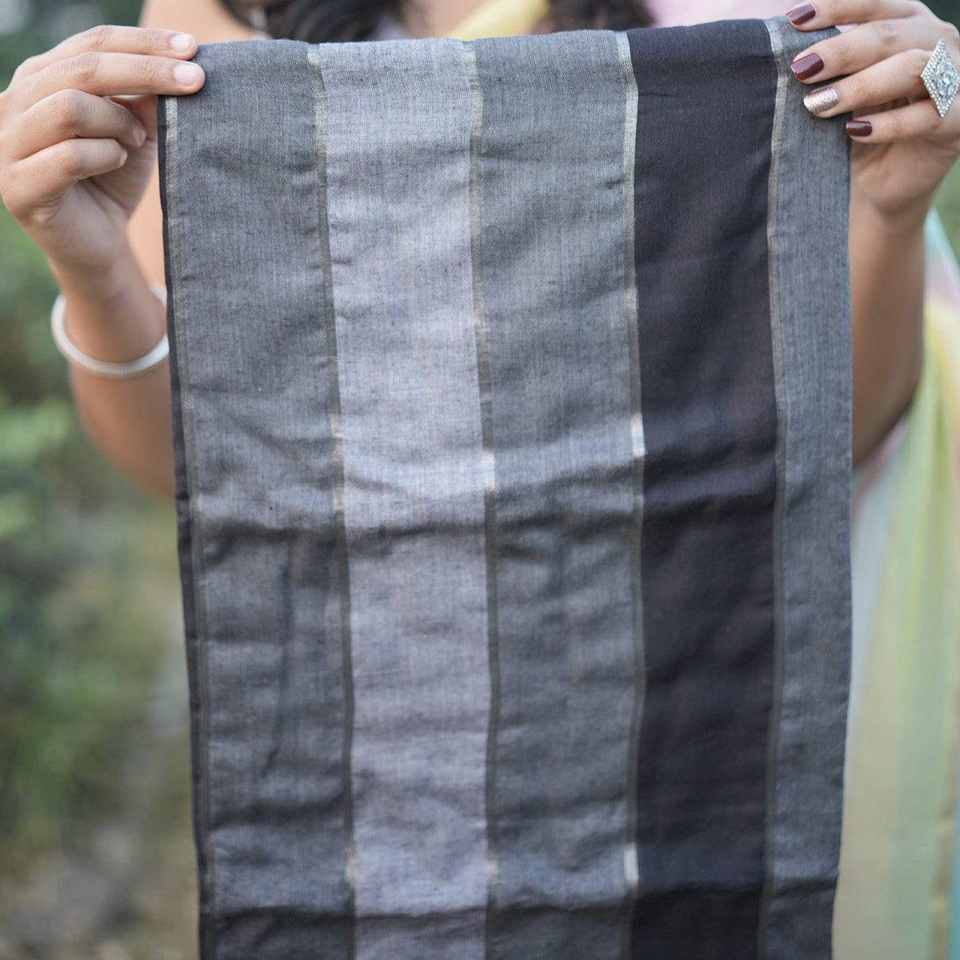 Woman holding a gray checkered fabric outdoors